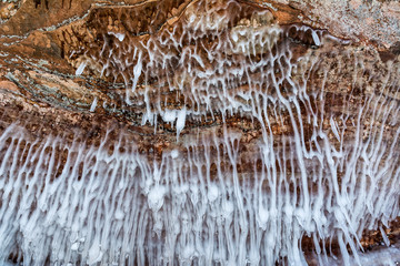 Strange ice formations hang from shoreline sandstone formations on Wisconsin's Apostle Islands National Lakeshore near Meyer's beach; Lake Superior.