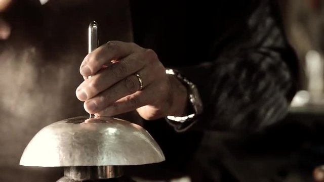 Master goldsmith working with silver-Refining a silver rod by drawing