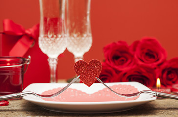 two forks holding red heart on wooden board, Valentines Day dinner