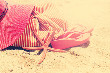 Fototapeta na wymiar Sand Beach Pink Sunhat Flip Flops Bag Starfish Holiday Concept