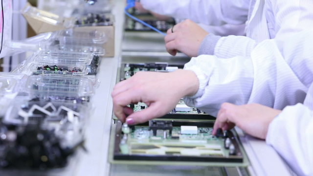 Workers are manufacturing Circuit Boards in Electronics Factory - Assembly line of LEDs, Transistors and other Electronic components being installed
