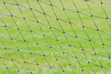 Fototapeta na wymiar close up on football net against green grass