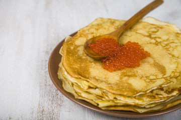 Pancakes with red caviar on a table