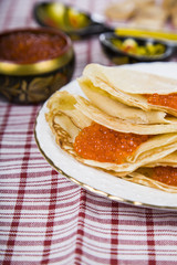 Delicious pancakes with red caviar on a table