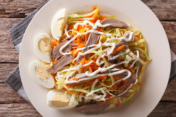 Beef heart with vegetables and eggs close-up on a plate horizontal top view
