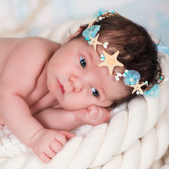 Close portrait of a sleeping newborn girl in the maritime hoop of starfish and pearls © Yarkovoy