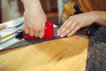 Man upholstering chair in his workshop