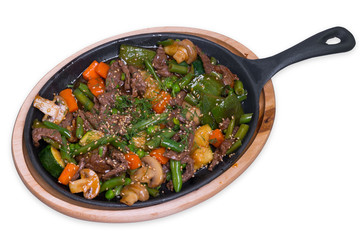 Roasted veal with mushrooms and vegetables in the iron pan, isolated