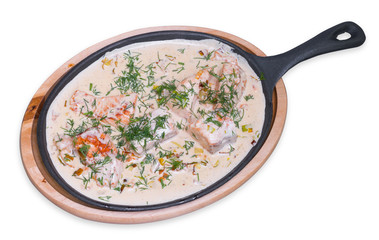 Salmon with sauce in a frying pan, isolated