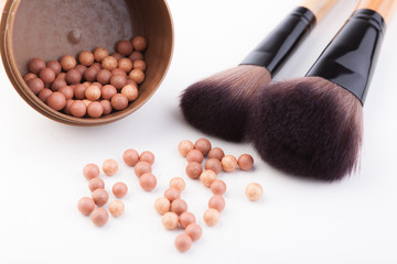Bronze beads blush with makeup brush isolated on white