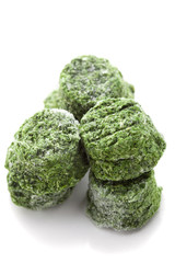 Fototapeta premium Frozen spinach cubes isolated on white, selective focus
