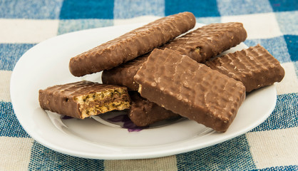 Plate with chocolate wafers on table.