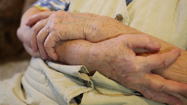 the folded hands of the elderly woman close-up