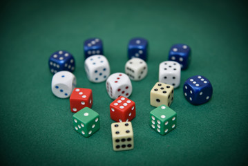 Different color dice on the green cloth. Selective focus.
