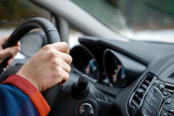 hands of man driving the car and holding wheel