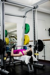 Fit woman lifting the barbell bench press