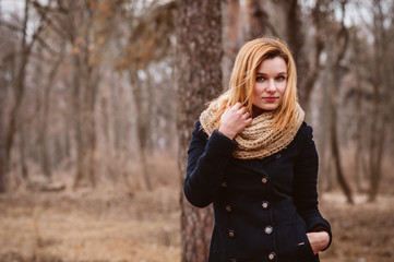 Portrait of young beautiful woman in autumn coat.