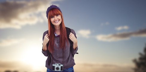 Composite image of portrait of a smiling hipster woman with a retro camera
