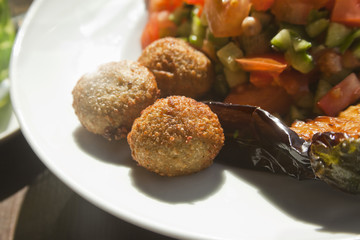 falafel close up with roasted eggplant and fresh vegetables. Street cafe
