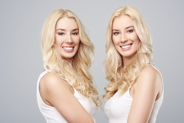 Blonde twins standing face to face.