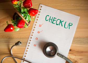 Health Check up list concept, top view of paper check list and Stethoscope on wood table , digital...