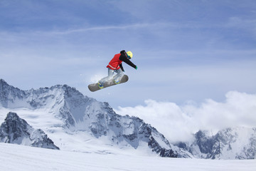 Flying snowboarder on mountains. Extreme sport.