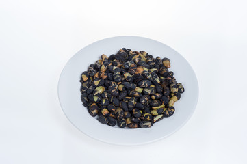 Black beans on white plate isolated on white background
