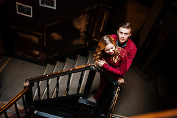 Fototapeta na wymiar Young beautiful stylish couple in a red dress in big wooden vint