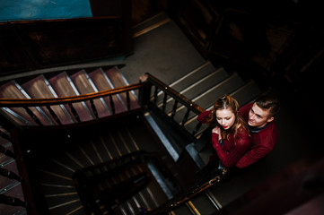 Young beautiful stylish couple in a red dress in big wooden vint