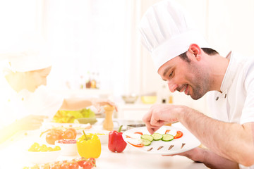 Young attractive professional chef cooking in his kitchen