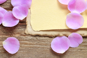 Vintage sheets of paper and pink rose petals