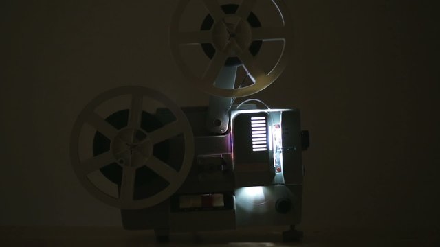Side view of an old-fashioned antique film projector. Includes projector audio