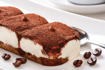 Tiramisu mit Kaffeebohnen, Löffel und Geschirr