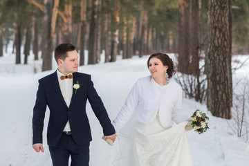couple newlyweds walking in a winter forest