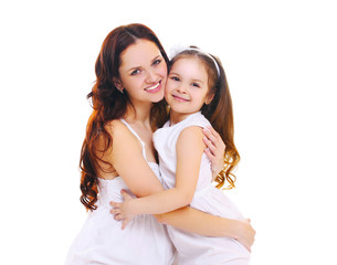Happy smiling mother hugging little child daughter on a white ba
