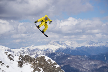 Flying snowboarder on mountains. Extreme sport.
