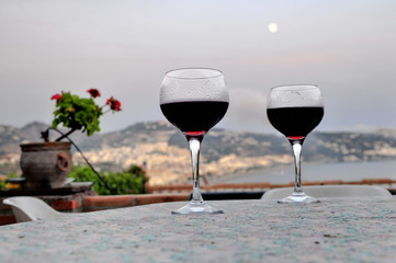 composición fotográfica de copas de vino tinto al atardecer.