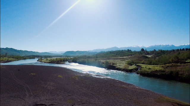 Summer landscape with river, field and blue sky