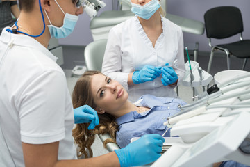 Naklejka na ściany i meble Dentist examining a patient's teeth in the dentist.