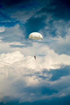Parachute jumper against dramatic sky