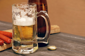 Beer in a glass on wooden background. Beer and beer snack.