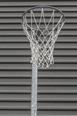 Closeup basketball hoop in the gym with corrugated metal wall ba