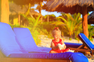 Fototapeta premium cute little baby girl with seashells on tropical beach