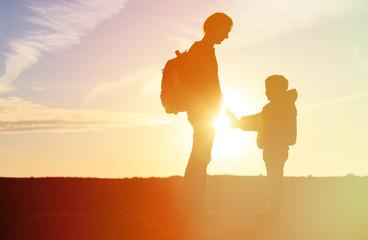 father and son travel at sunset