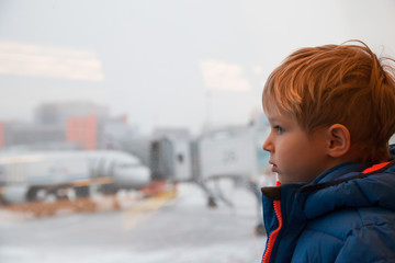 little boy looking at planes in the airport