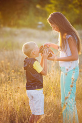Mother and son outdoors on a summer sunset enjoying their time together on vacation, lifestyle concept