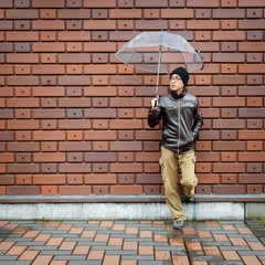 An Asian Man in a Brown Jacket With a Clear Umbrella