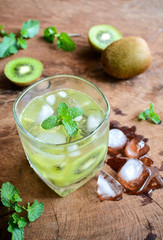 Cocktail with kiwi and mint in a glass on a wooden background