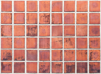 Old red tiling on the wall, grungy background