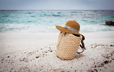 Straw hat and bag on a tropical beach